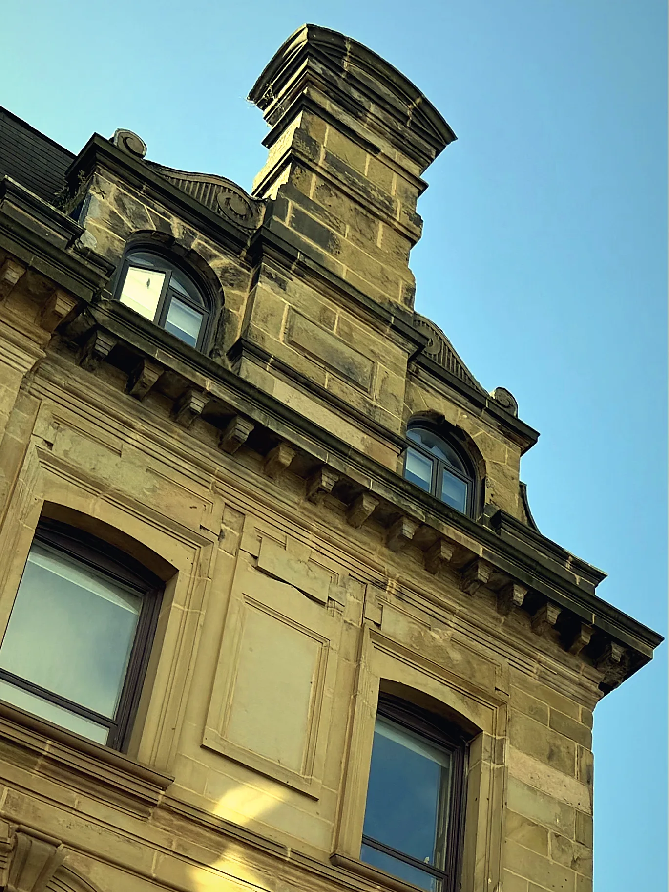 Ornate sandstone building corner against a blue sky