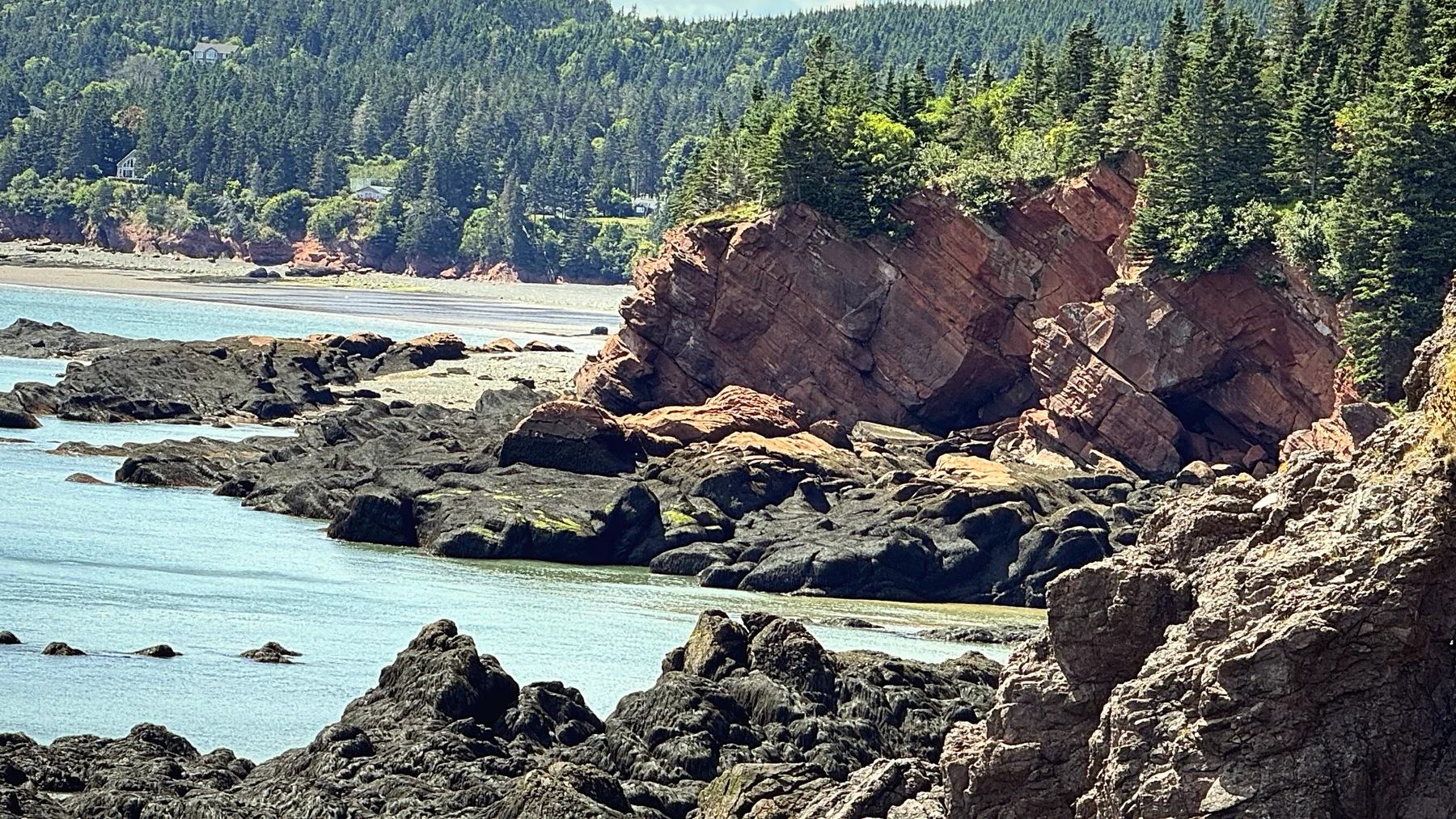Red rock cliffs and tidal pools along the Bay of Fundy shore
